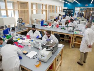 Gloucester Biotechnology Academy volunteer and retired biotechnology professional, Joseph Rosa, PhD, supervises students in the new biomanufacturing learning environment, built in 2021.
