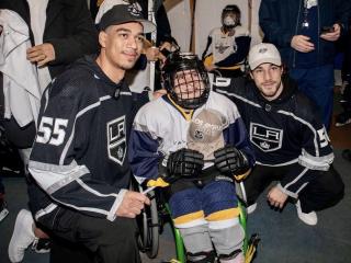 LA Kings players pose with a child from SNAP Flyers Hockey Club.