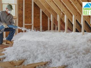 ENERGY STAR: Rule your attic. Worker shown blowing in insulation into an attic space.
