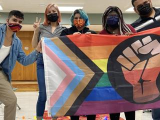 Latino Equity Alliance group with a LGBTQ+ flag