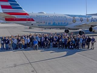 Aerial view of a large group of people in front of the Medal of Honor plane
