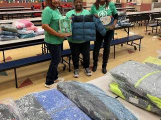 International Paper volunteers smiling with a child's coat 
