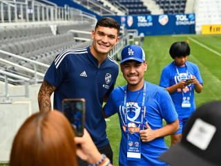 Student posing with an MLS player