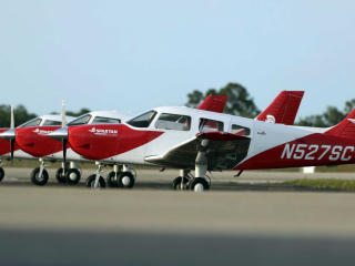 Three small planes parked on a runway