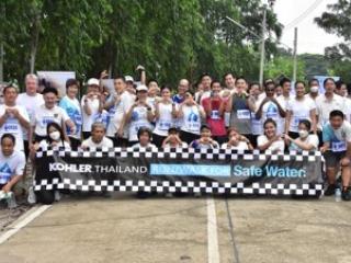 Group photo holding up Kohler Thailand Safe Water sign