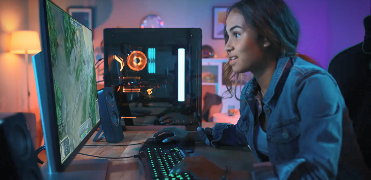 A person playing a game on a desktop computer, using the keyboard as a controller. 