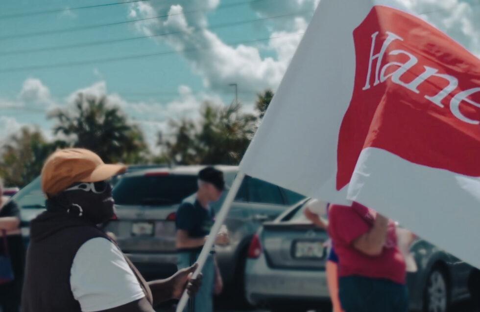 Woman holding a HanesBrands flag.