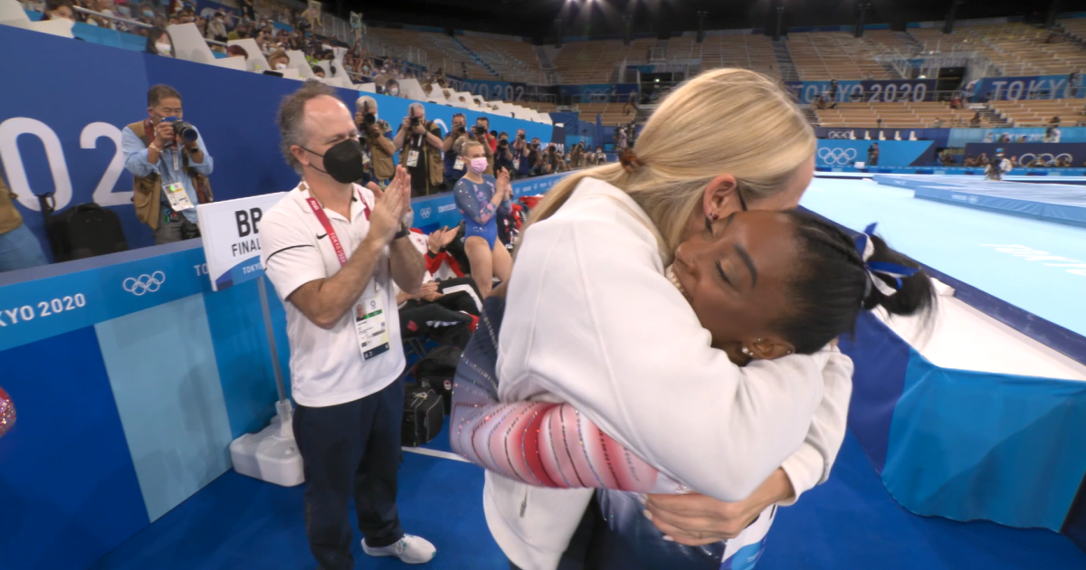 Ceci and Simone hug on the sidelines of a gymnastics competition