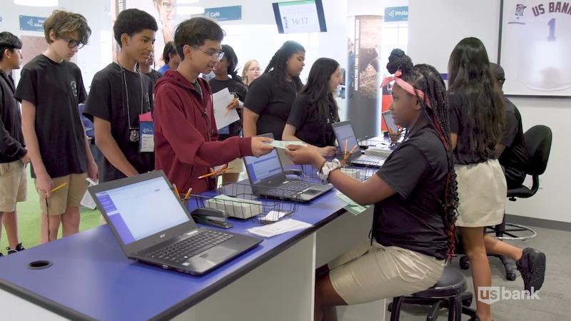 Hope Academy students shown working as bankers for the day.