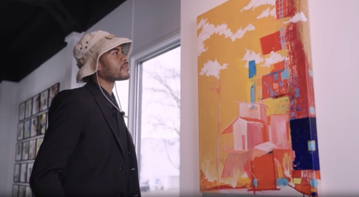 Justin Ellis looking at art hung up on the wall