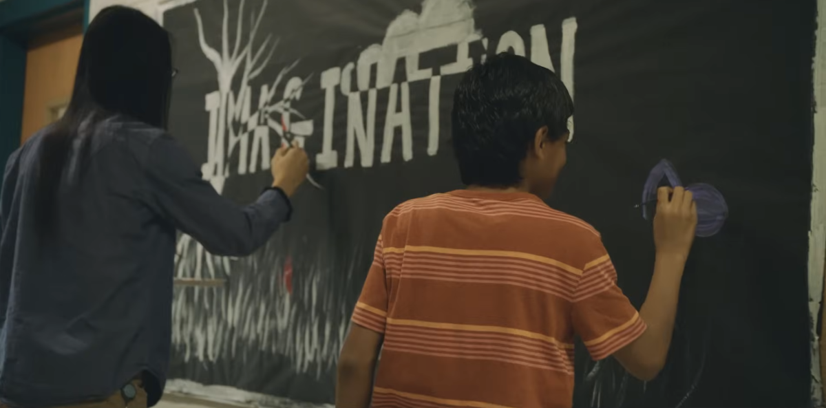 A child writing on a black board 