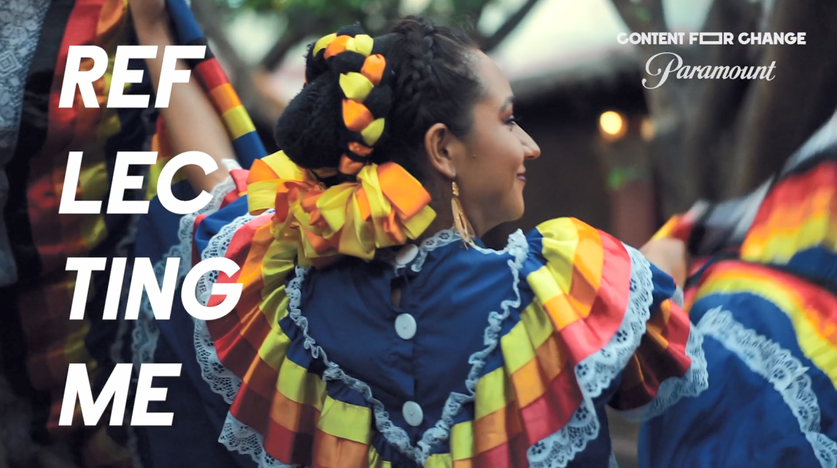 A person dancing in colorful dress. "Reflecting me" on the side.