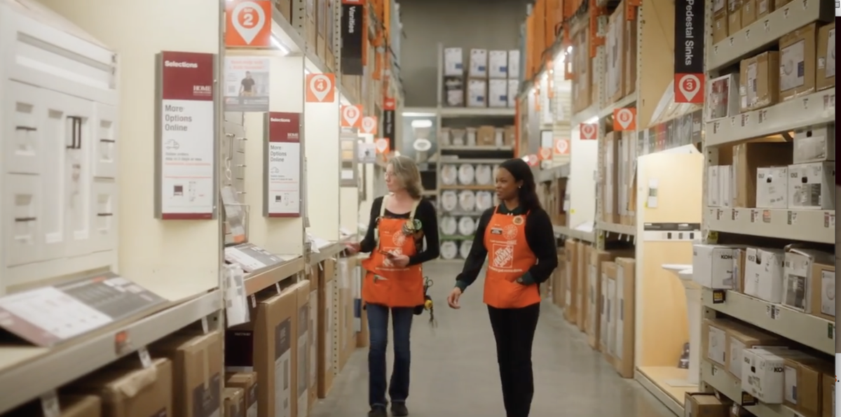 Kierra Blake and an employee walking through aisle in Home Depot store