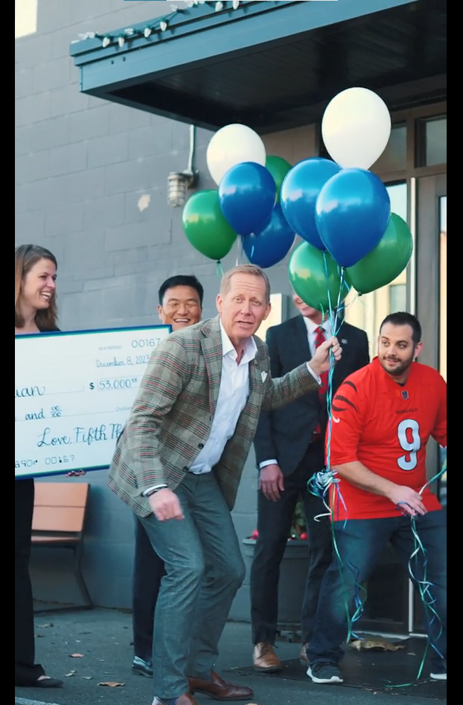 Group with a large check, balloons, getting ready to go inside the RODI restaurant