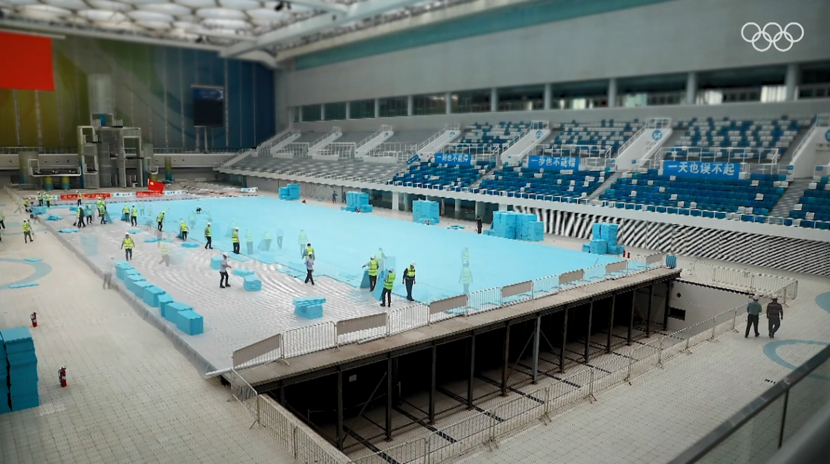 Workers drain a swimming pool and install a rink on top.