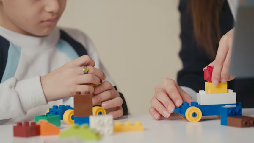 A child and an adult using building blocks