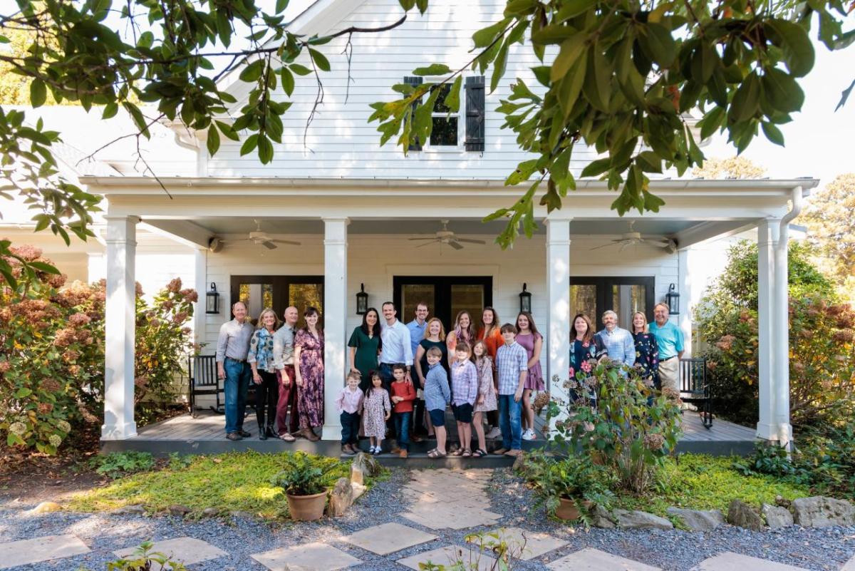 family stands in front of house