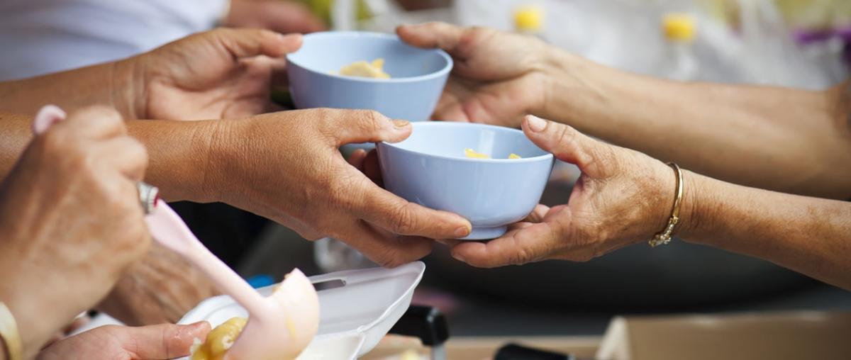 Hands sharing bowls of food