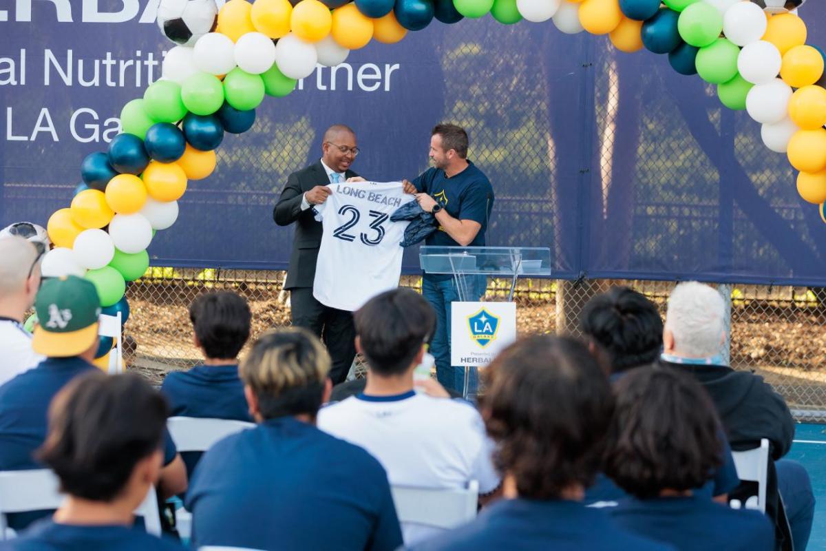 LA Galaxy's President Chris Klein presents Long Beach Mayor Rex Richardson with a customized jersey at the ceremony.