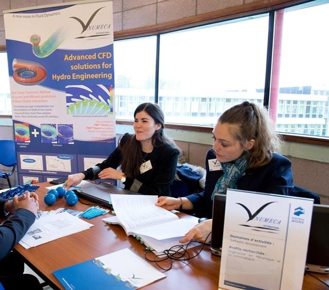 Virginie Barbieux and coworker in dark blue blazers sitting at a table