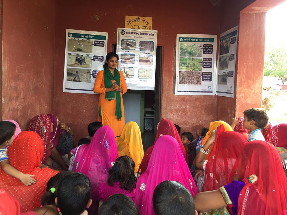 one person stands in front of a small crowd with posters behind them