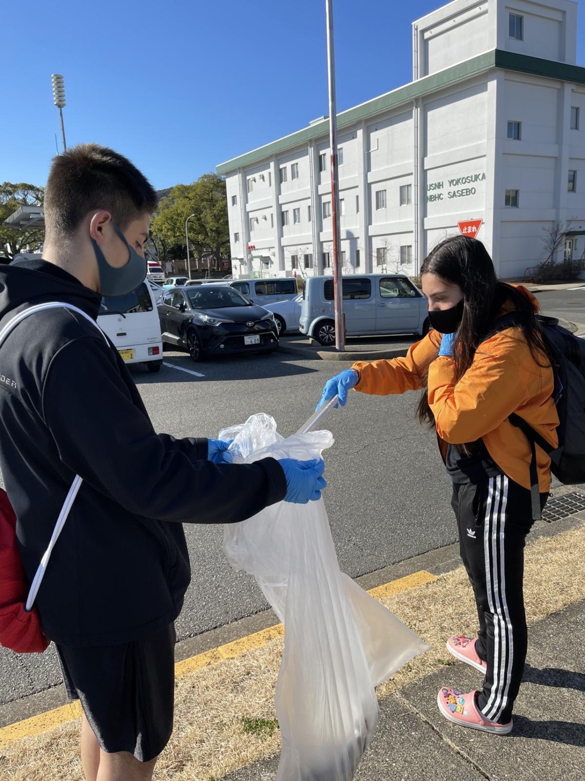 two people picking up litter