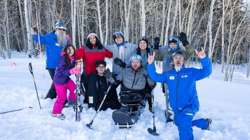 Photo courtesy of Vail Veterans Program People posing with skis on snowy mountain