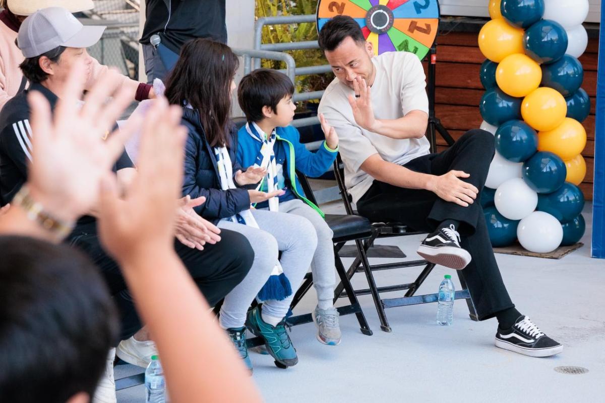 LA Galaxy's Maya Yoshida high-fives a participant.