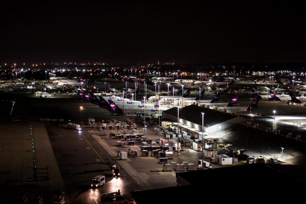 Aerial view of FedEx planes and cargo at an airport at night
