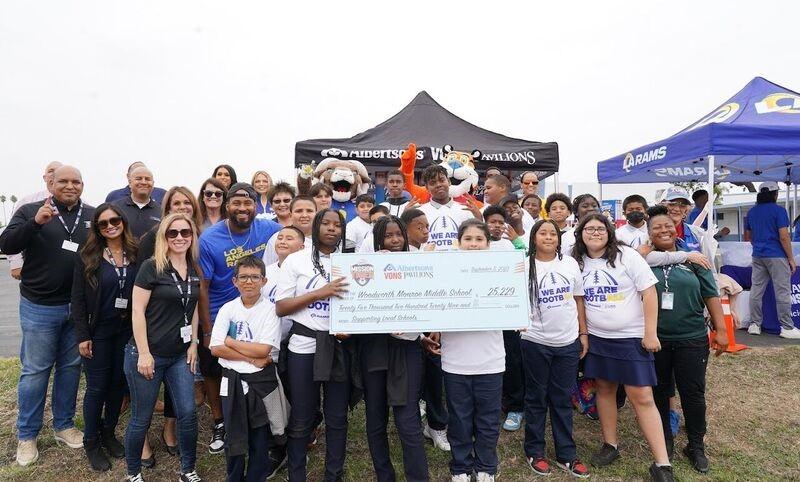 Group of people holding a check in front of Albertsons' tent