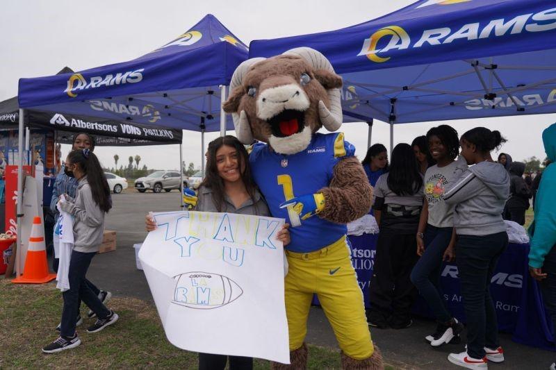 Los Angeles Rams' mascot poses with person holding a "Thank you" sign
