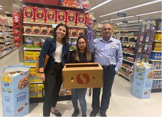 Group of people in store holding Safeway donation box
