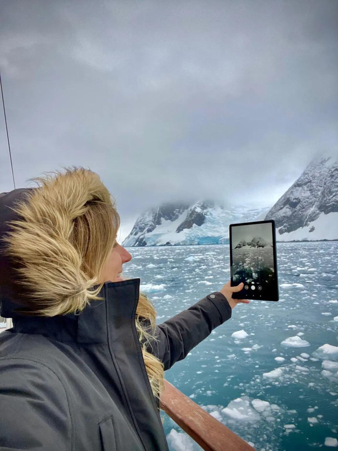 Gádor in a parka, viewing icy water through a tablet screen