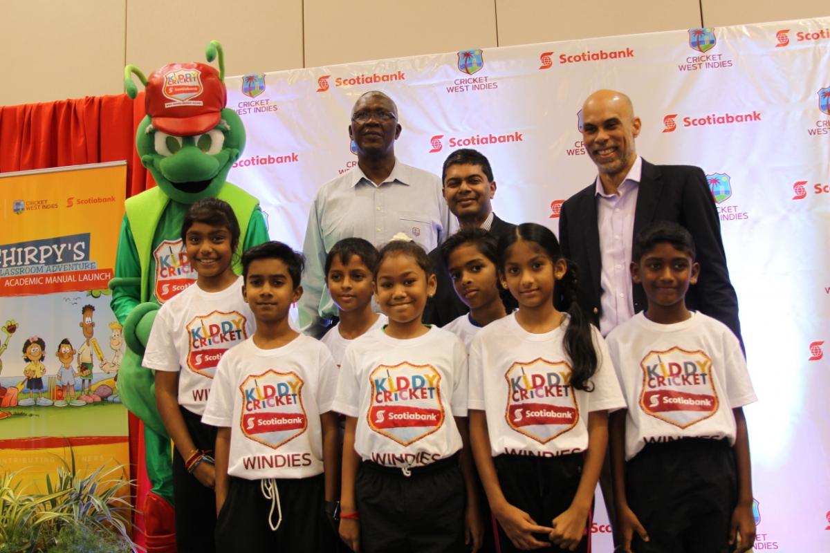 Back row (left to right) Kiddy Cricket mascot Chirpy; former West Indies player Joel Garner, CWI ambassador; Reshard Mohammed, Scotiabank VP; and director of cricket at CWI, former West Indies player Jimmy Adams pose with youngsters yesterday at the launch of Scotia’s Kiddy Cricket Academic Manual at the Hyatt Regency, PoS. PHOTO BY RATTAN JADOO