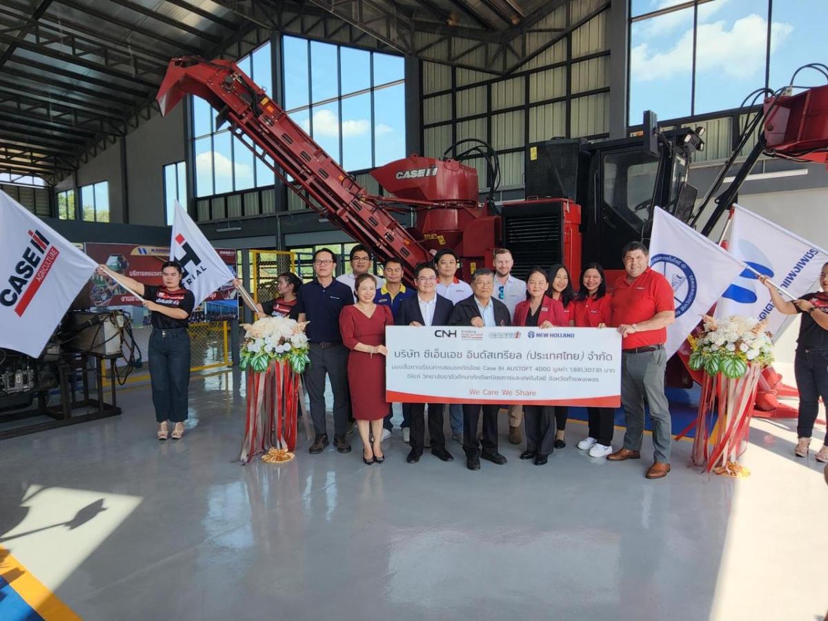 A group of people stood in front of agricultural machinery 