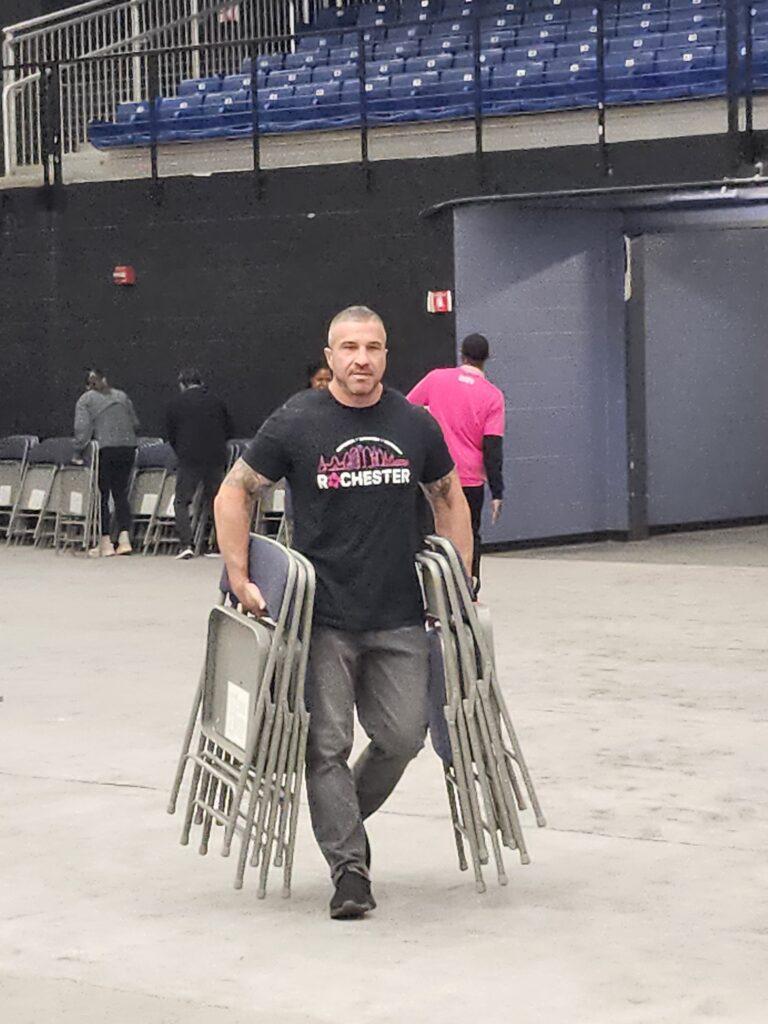 Person carrying chairs