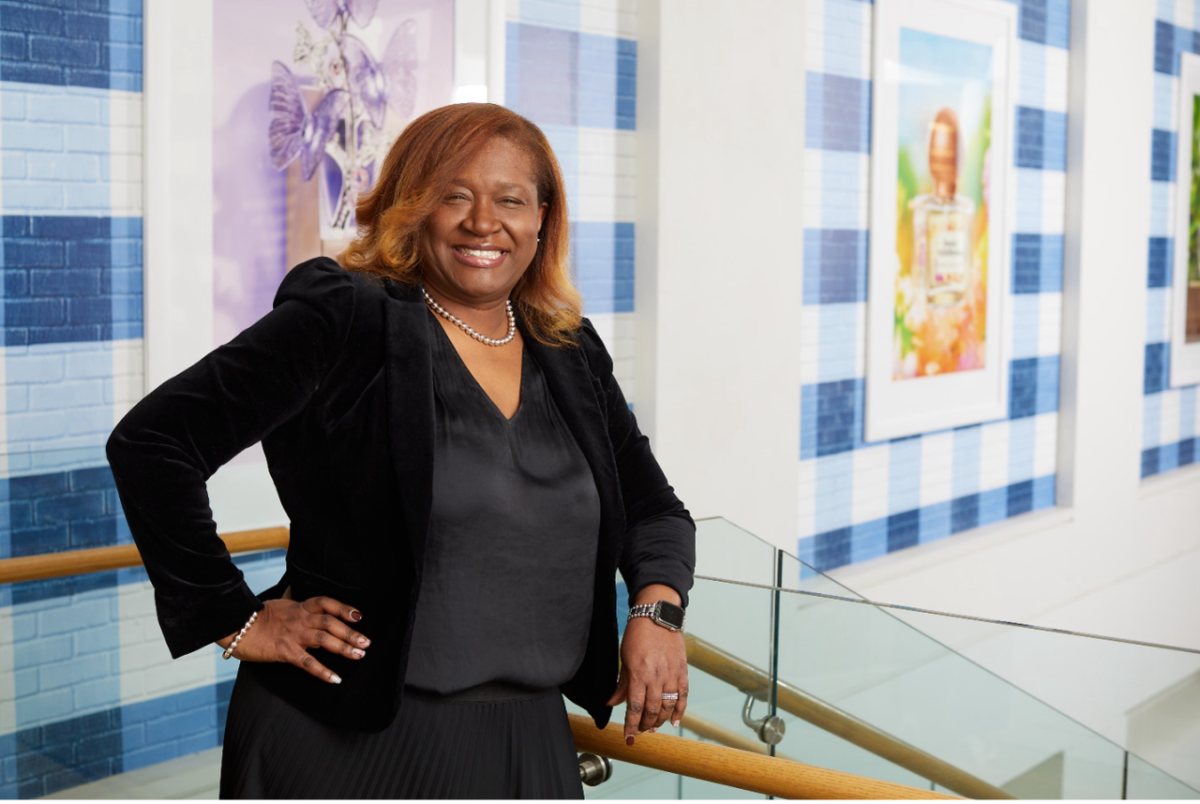 Kelie Charles smiles at the camera while standing at the top of a set of steps at the Bath & Body Works headquarters building in Columbus, Ohio.