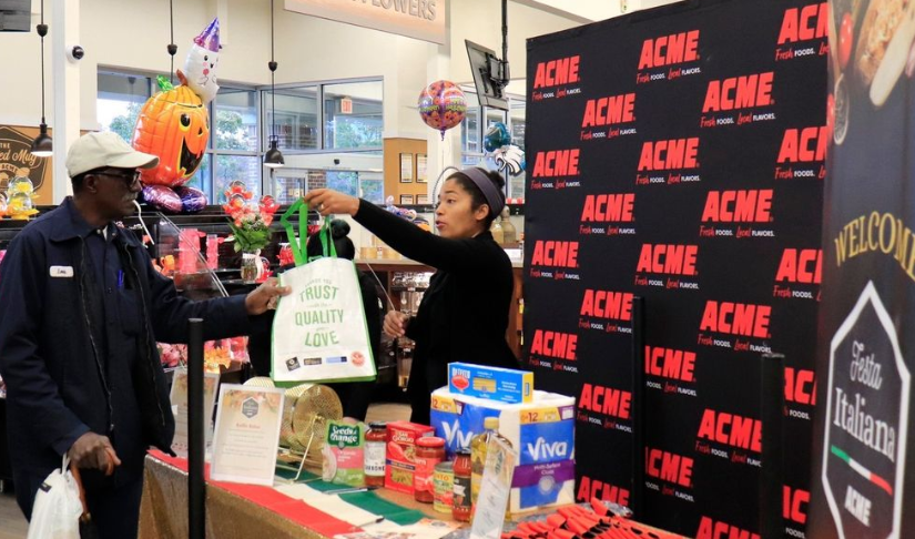 Someone at a booth handing a bag to a customer