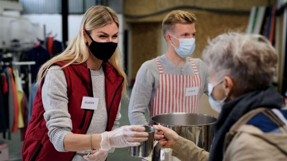 Woman hands out beverage.