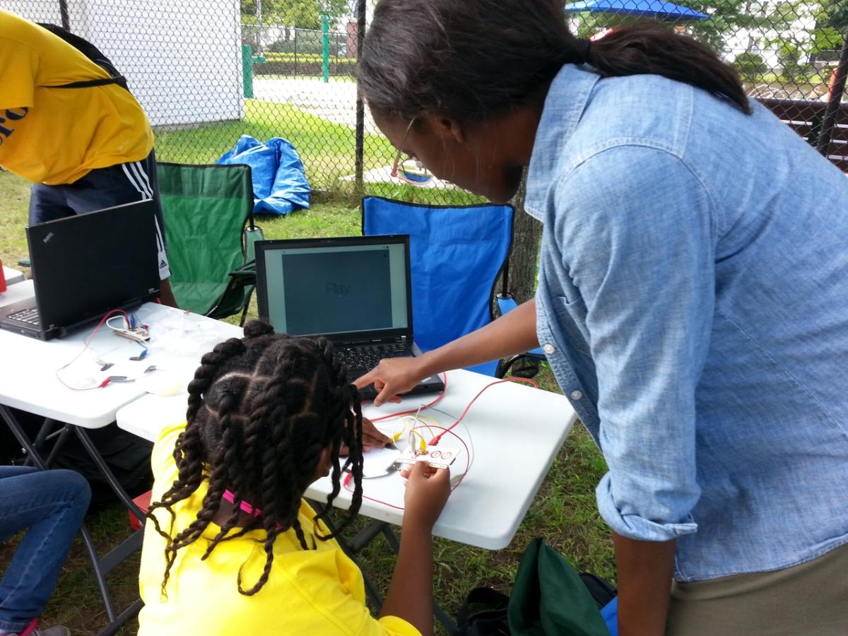 Adult showing laptop to child