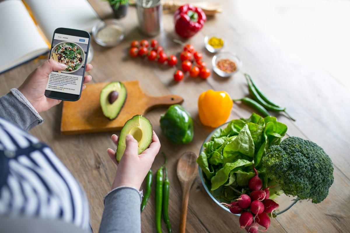 Preparing a meal while looking on a smartphone