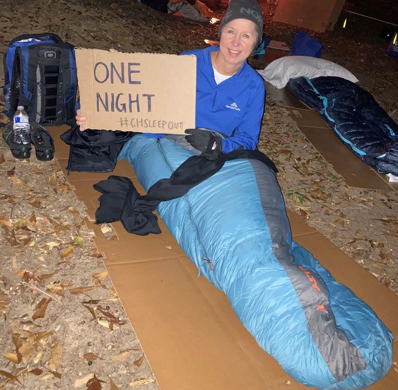 Anna Umphress in sleeping bag holding One Night #CHSLEEPOUT sign