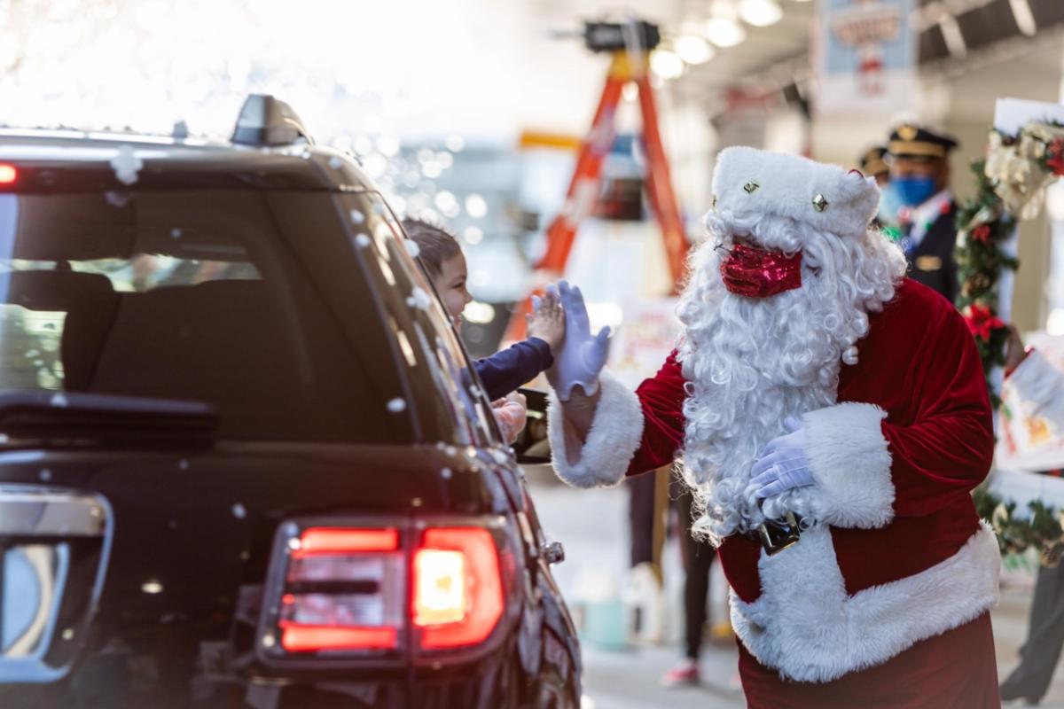 Santa high-fiving child in car