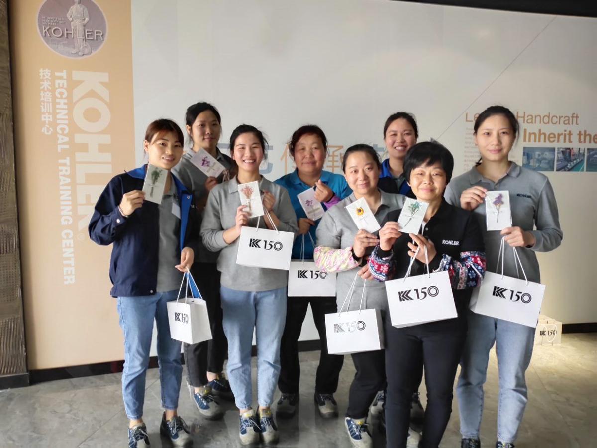 Group of women holding Kohler bags