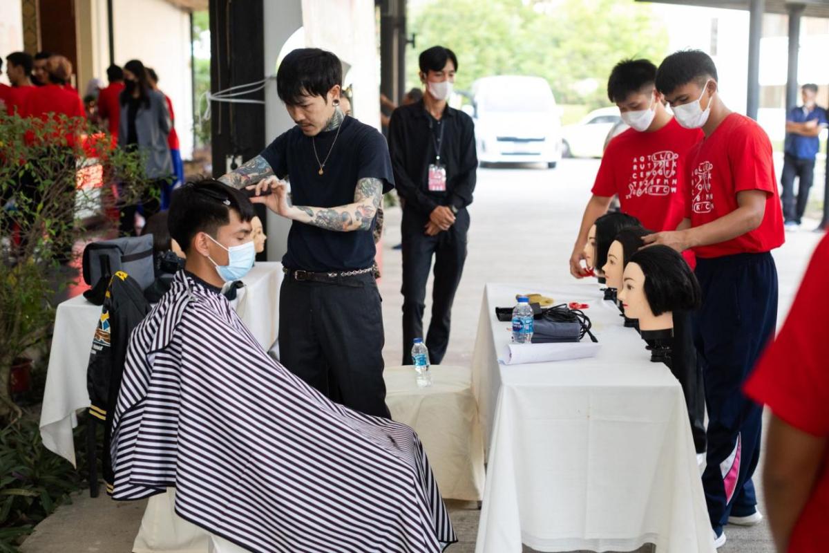 A person sat in a chair getting their hair cut