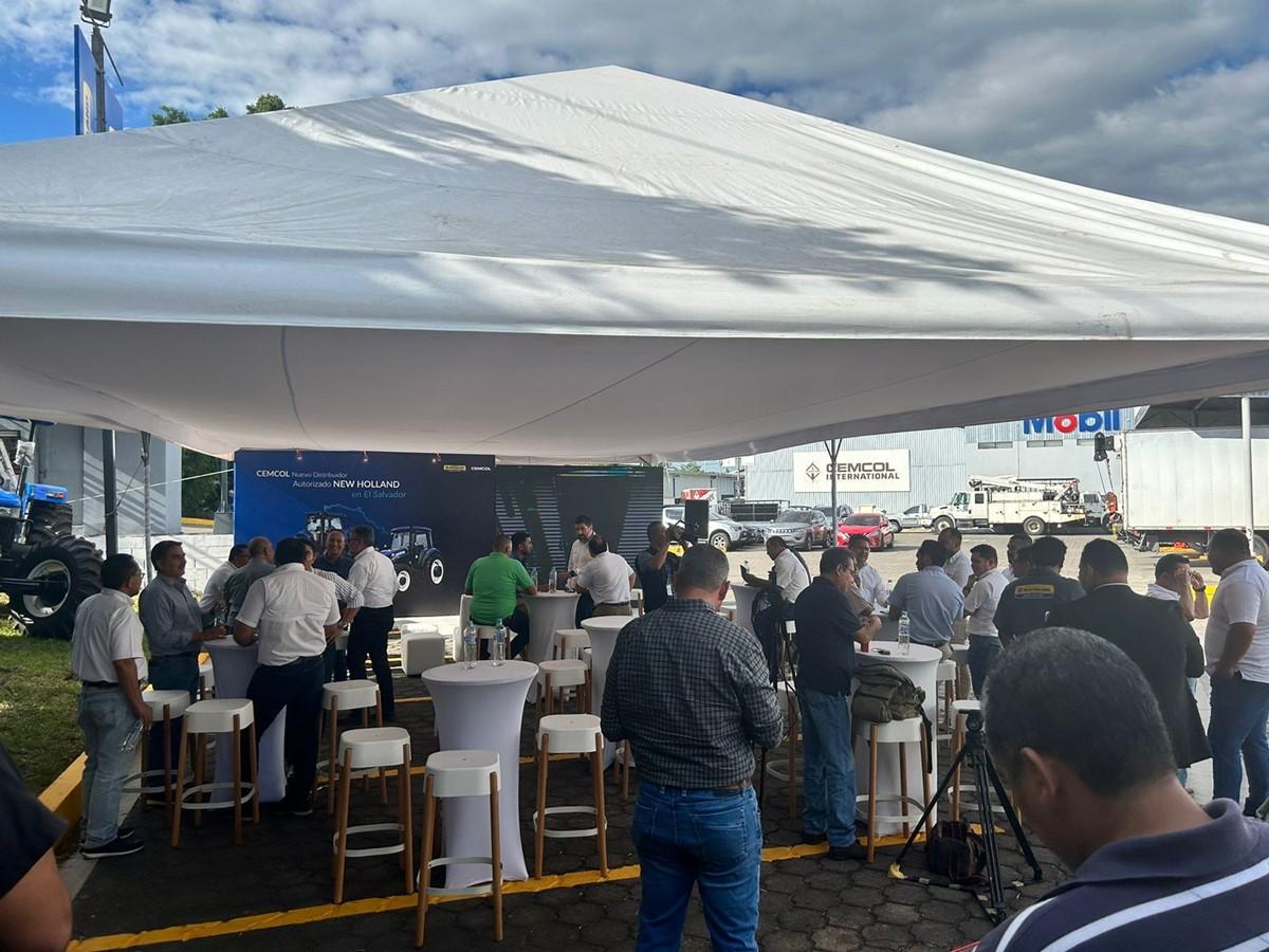 People attending an outdoor event, stood underneath a canopy 