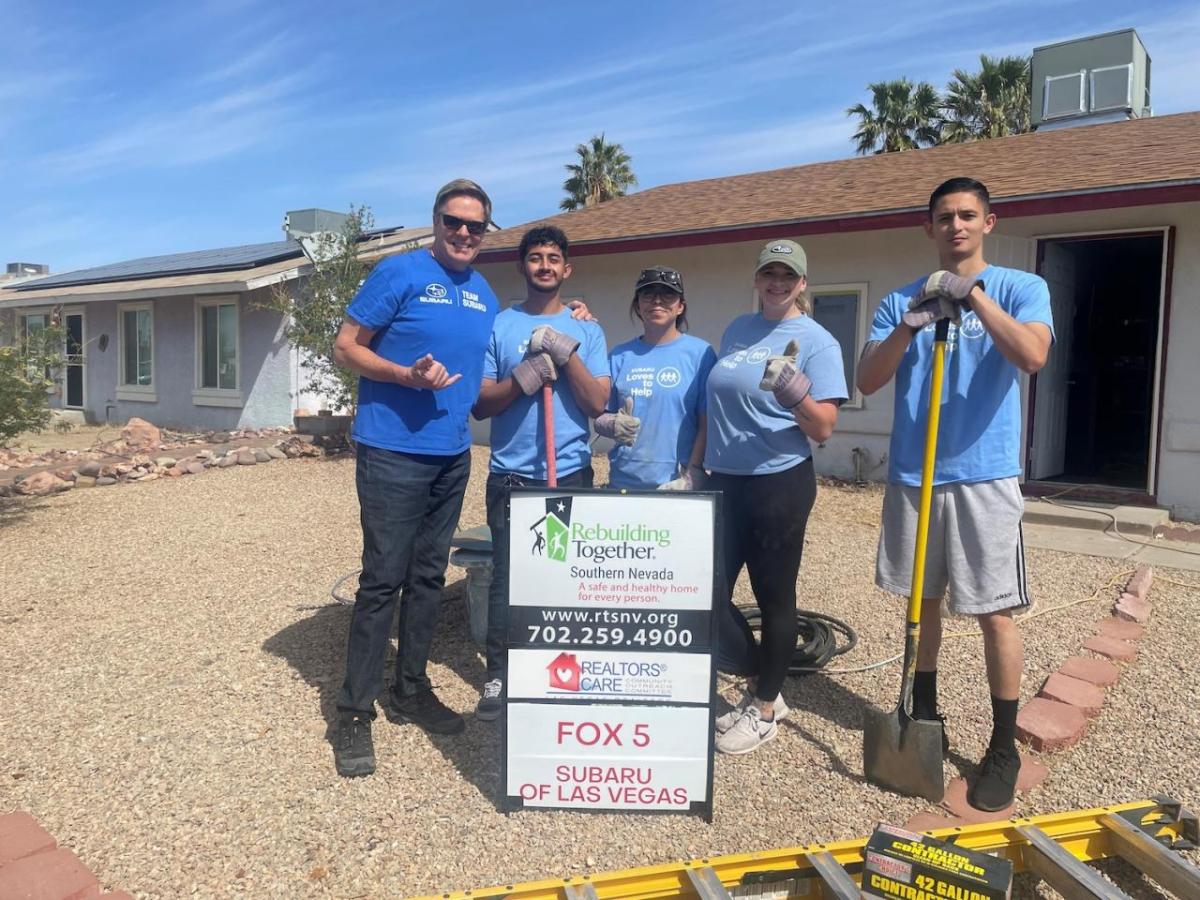 People posing together in front of a house