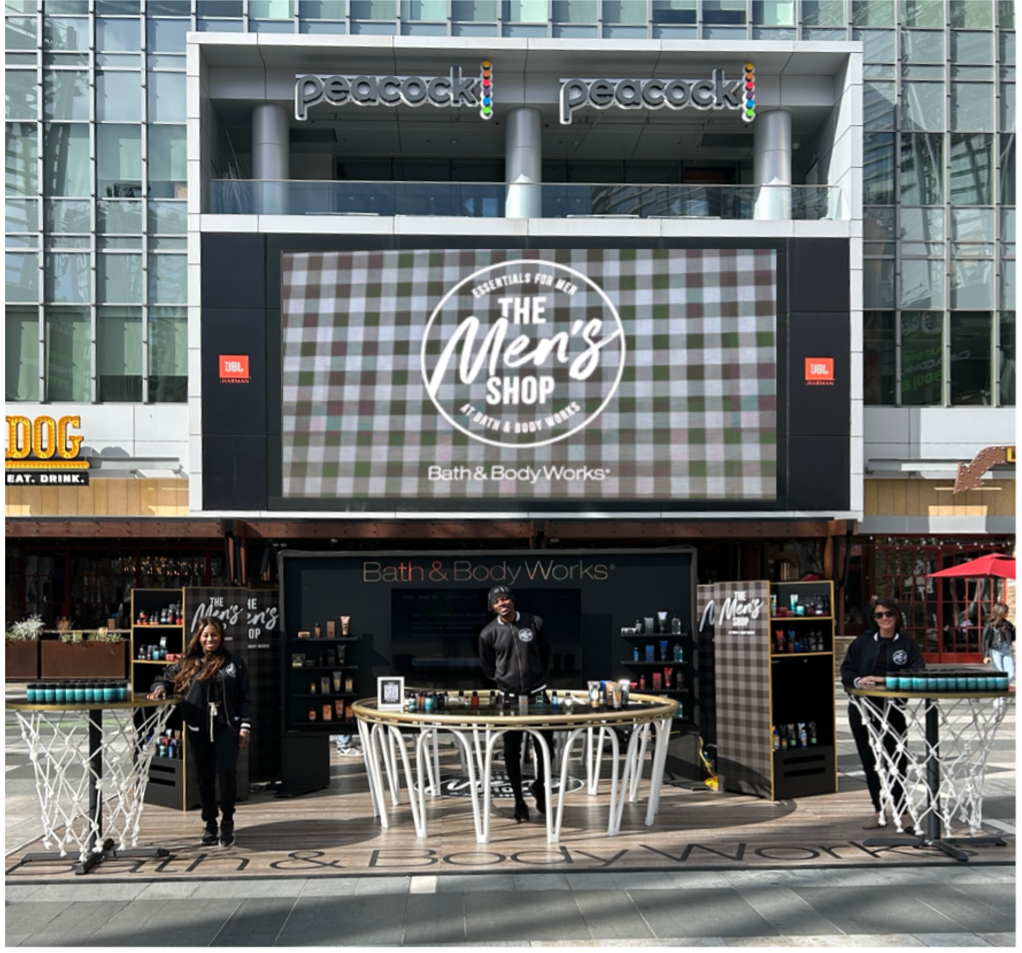 A view of "The Men's Shop" from outside, with people standing by tables