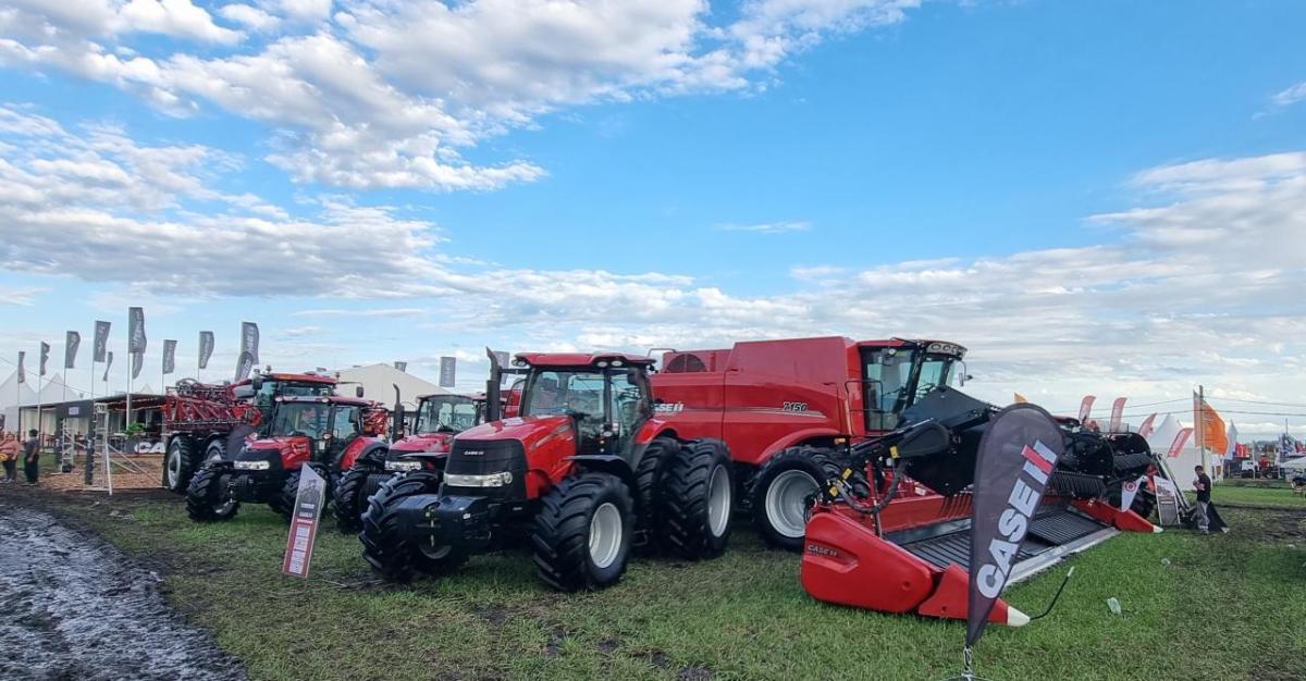 Tractors and equipment in a field under a cloudy sky