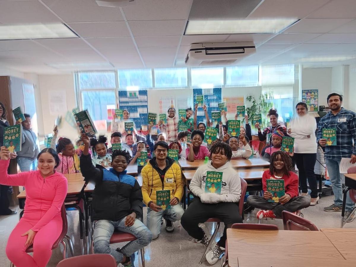 Students holding up books in classroom